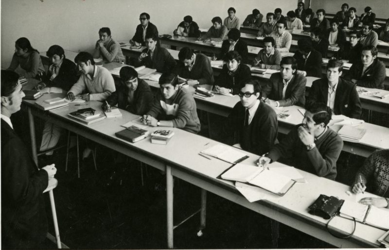 Dictado de clases en una de las aulas de la Facultad de Ingeniería a comienzos de los años setenta. En el lado izquierdo de la imagen se aprecia a la única alumna del aula. Foto: Archivo PUCP.